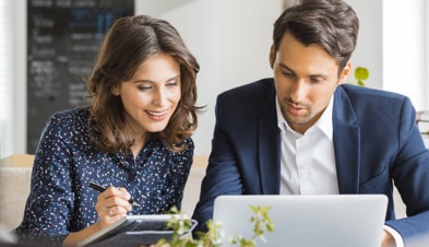 Two business professionals collaborating on a laptop