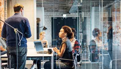 Team meeting in industrial office space with glass conference room doors