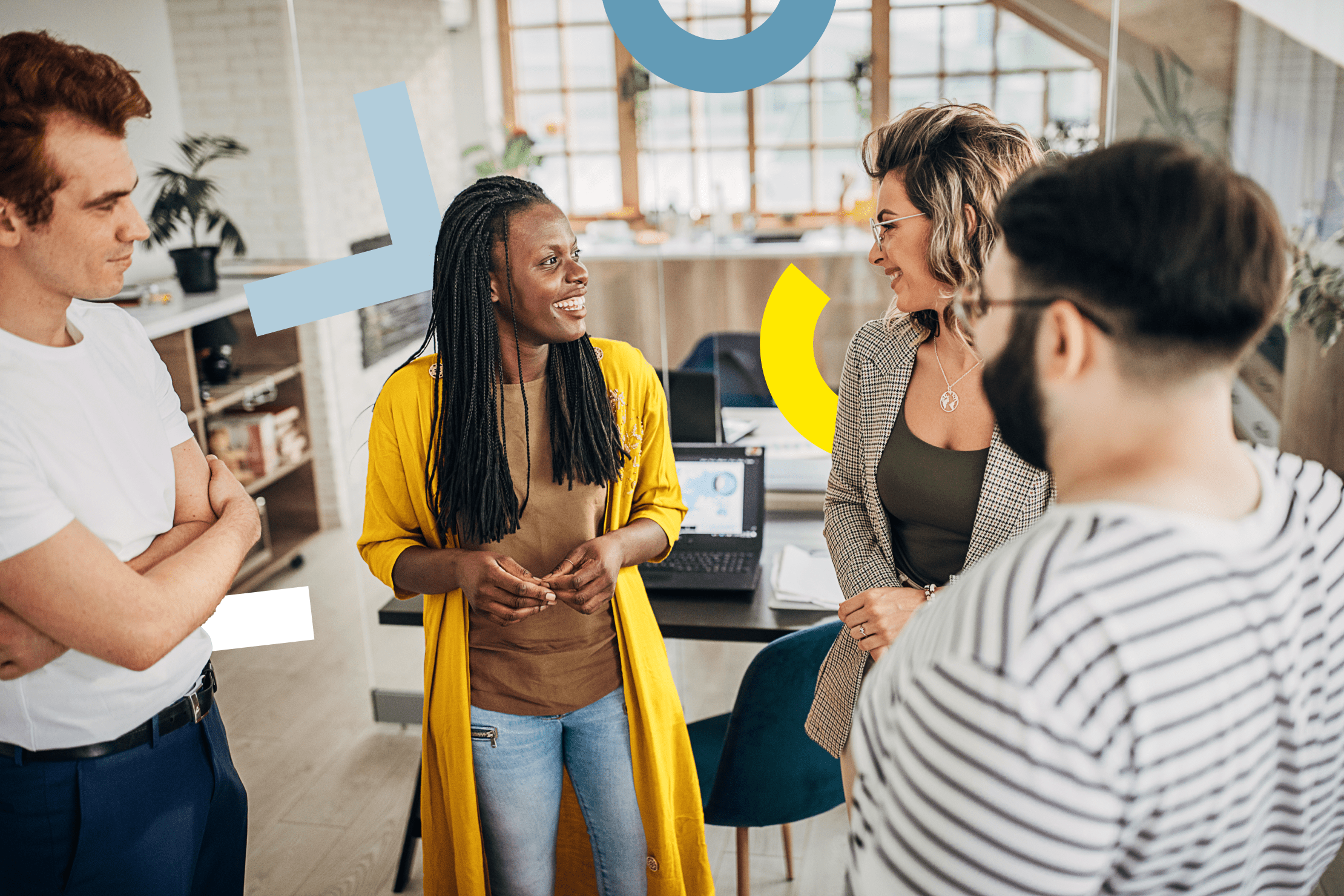 Group of individuals in a small business office setting having a casual discussion.