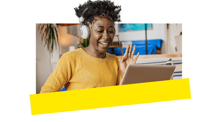 An employee smiling while attending a GoToConnect conference call on her laptop.